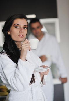 Young love couple taking fresh morning cup of coffee in the modern appartment