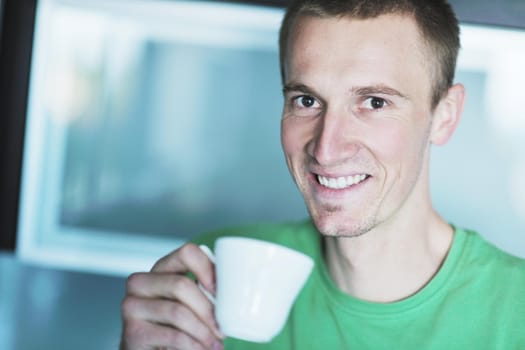 handsome young man drink fresh morning coffee from white cup