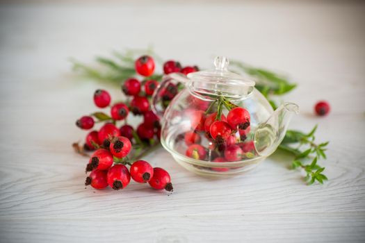 a bunch of ripe red rose hips on a wooden table