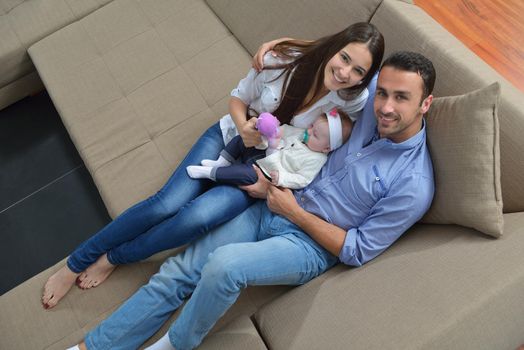 happy young family couple with beautiful new born baby have fun at home