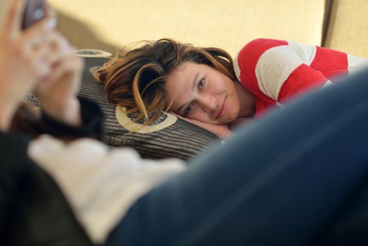 beautiful young woman relax and work on laptop computer while listening music on heaphones and read book at home