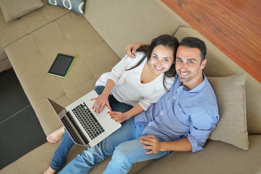 happy young relaxed couple working and playing on laptop computer at home