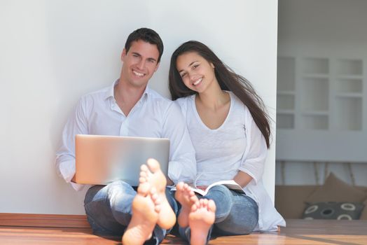 happy young relaxed couple working and playing on laptop computer at home