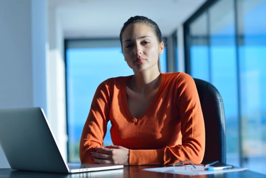 beautiful young woman relax and work on laptop computer while listening music on heaphones and read book at home