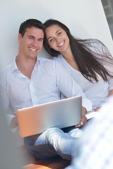 happy young relaxed couple working and playing on laptop computer at home