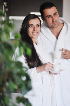 Young love couple taking fresh morning cup of coffee in the modern appartment