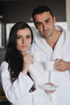 Young love couple taking fresh morning cup of coffee in the modern appartment