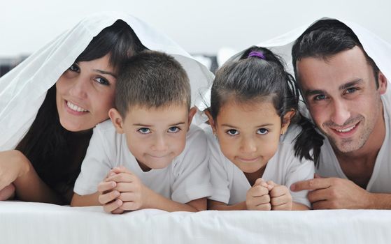 happy young Family in their bedroom have fun and play in bed