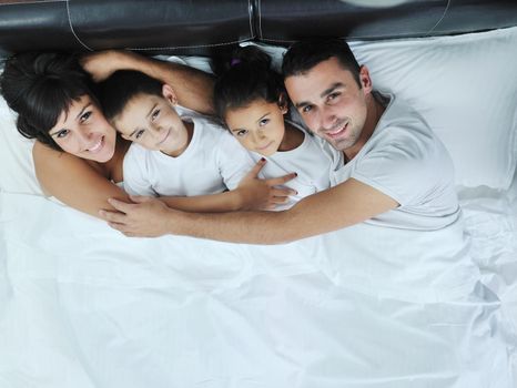 happy young Family in their bedroom have fun and play in bed