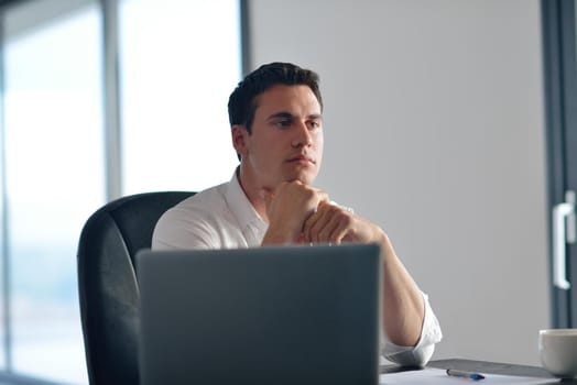 portrait of young happy business man working on laptop computer at home