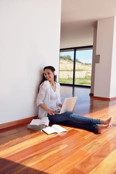 beautiful young woman relax and work on laptop computer while working on laptop computer and read book at home