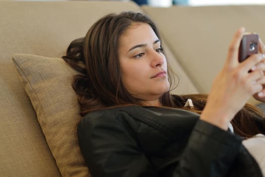 beautiful young woman relax and work on laptop computer while listening music on heaphones and read book at home