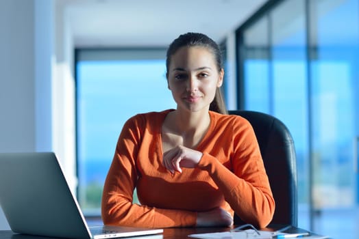 beautiful young woman relax and work on laptop computer while listening music on heaphones and read book at home