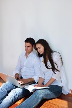 happy young relaxed  couple working on laptop computer at modern home indoor