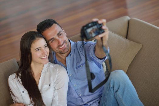 happy young  couple playing with digital camera at home