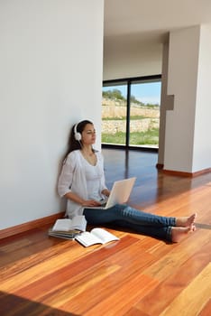 beautiful young woman relax and work on laptop computer while working on laptop computer and read book at home