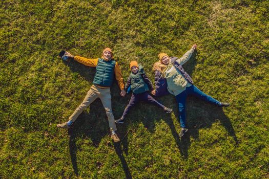 family top view. lying on the grass. sunny day. in green nature together. Aerial view Drone photography.