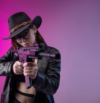 the sexy woman with an automatic rifle in black leather clothes and hat