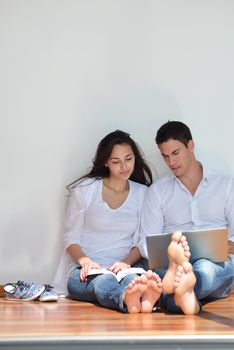 happy young relaxed  couple working on laptop computer at modern home indoor