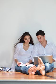 happy young relaxed  couple working on laptop computer at modern home indoor