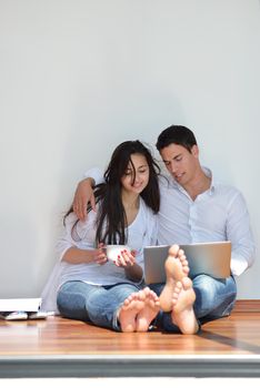 happy young relaxed  couple working on laptop computer at modern home indoor