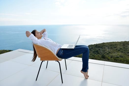 beautiful young woman relax and work on laptop computer while working on laptop computer and read book at home