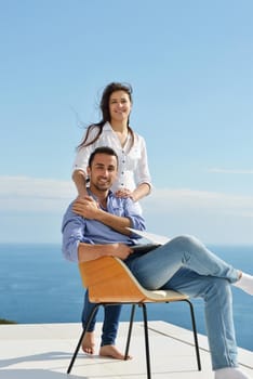 happy young relaxed  couple working on laptop computer at modern home indoor