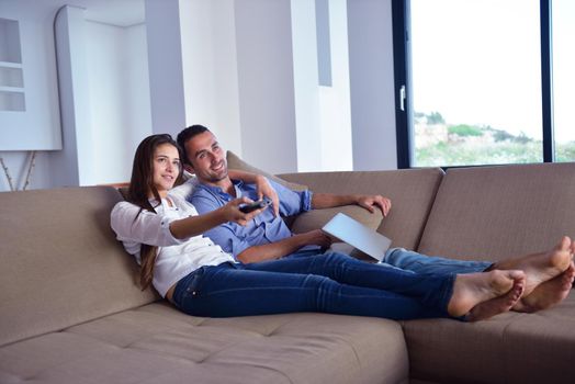 Couple on sofa with TV remote
