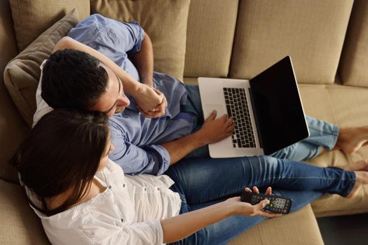 happy young relaxed  couple working on laptop computer at modern home indoor