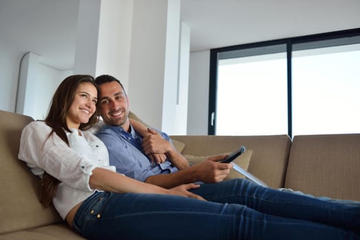 Couple on sofa with TV remote