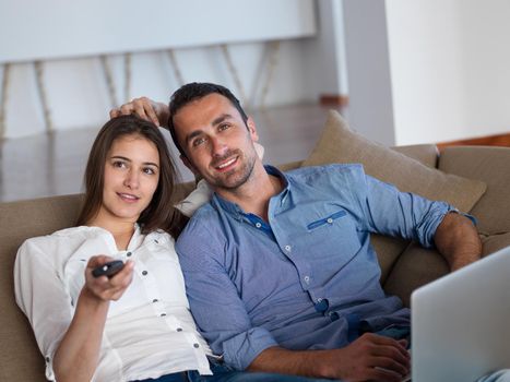 happy young relaxed  couple working on laptop computer at modern home indoor