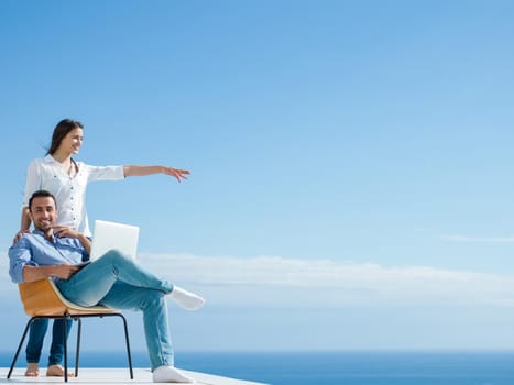 happy young relaxed  couple working on laptop computer at modern home indoor