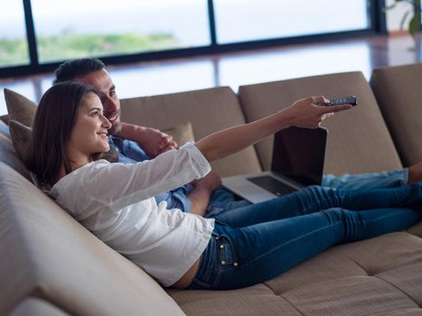 happy young relaxed  couple working on laptop computer at modern home indoor