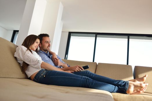 Couple on sofa with TV remote