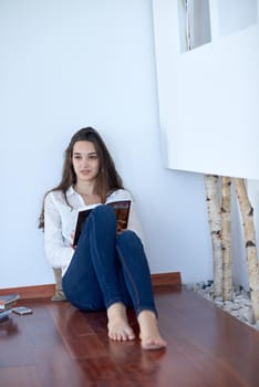 beautiful young woman relax and work on laptop computer modern  home office while listening musin on white headphones