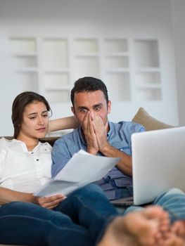 happy young relaxed  couple working on laptop computer at modern home indoor