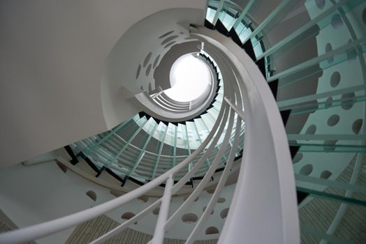 modern glass spiral staircase with metallic hand-rails.