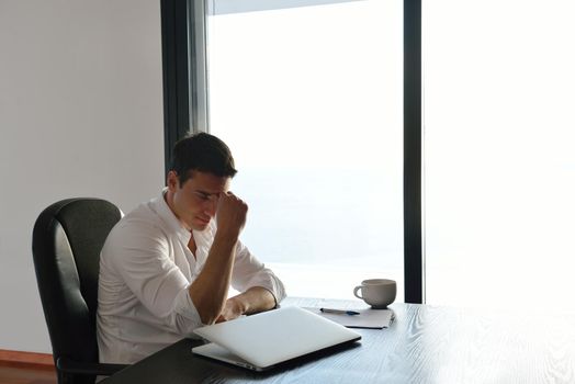 frustrated with problems young business man working on laptop computer at home