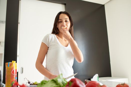 Young Woman Cooking in the kitchen. Healthy Food - Vegetable Salad. Diet. Dieting Concept. Healthy Lifestyle. Cooking At Home. Prepare Food