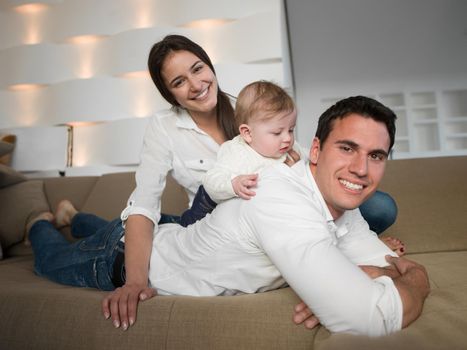 happy young family couple with beautiful new born baby have fun at modern  home
