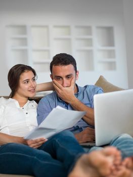 happy young relaxed  couple working on laptop computer at modern home indoor