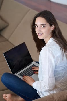 beautiful young woman relax and work on laptop computer modern  home office while listening musin on white headphones