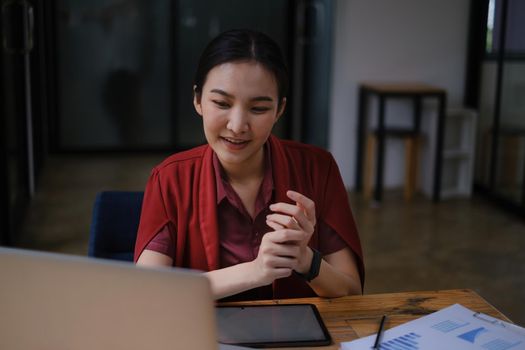 Business woman speaking on video call on online briefing with laptop computer at her office.