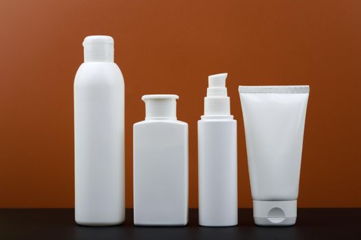 Set of beauty products for man skin care on black table against dark brown background. 