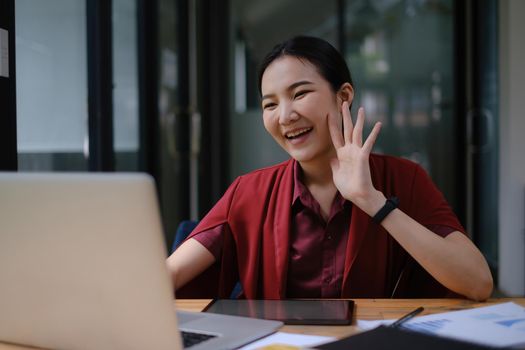 Portrait of a cheerful woman having video call on laptop computer at home.