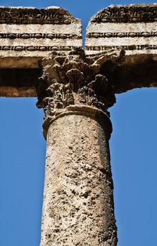 ancient white column supporting structure with blue sky in background