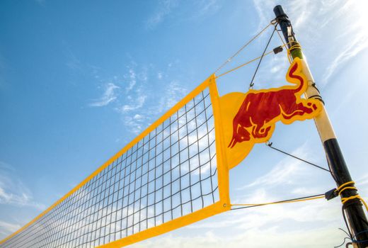 yellow volleyball net against blue cloudy sky