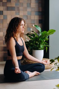 A young woman in black clothes is doing yoga in a modern gym.The concept of health.