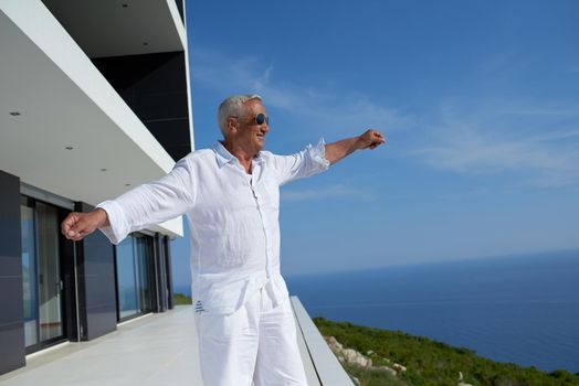 senior man in front of luxury modern home villa