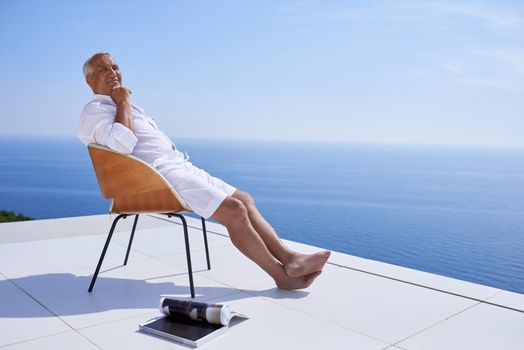 senior man in front of luxury modern home villa